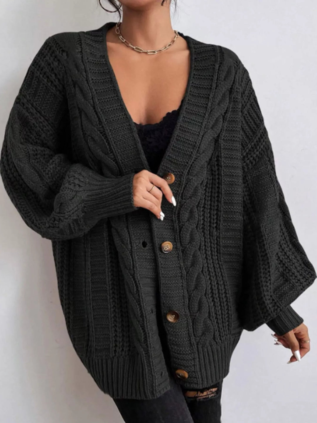 Chunky cable knit button front v-neck in black, styled on model 2