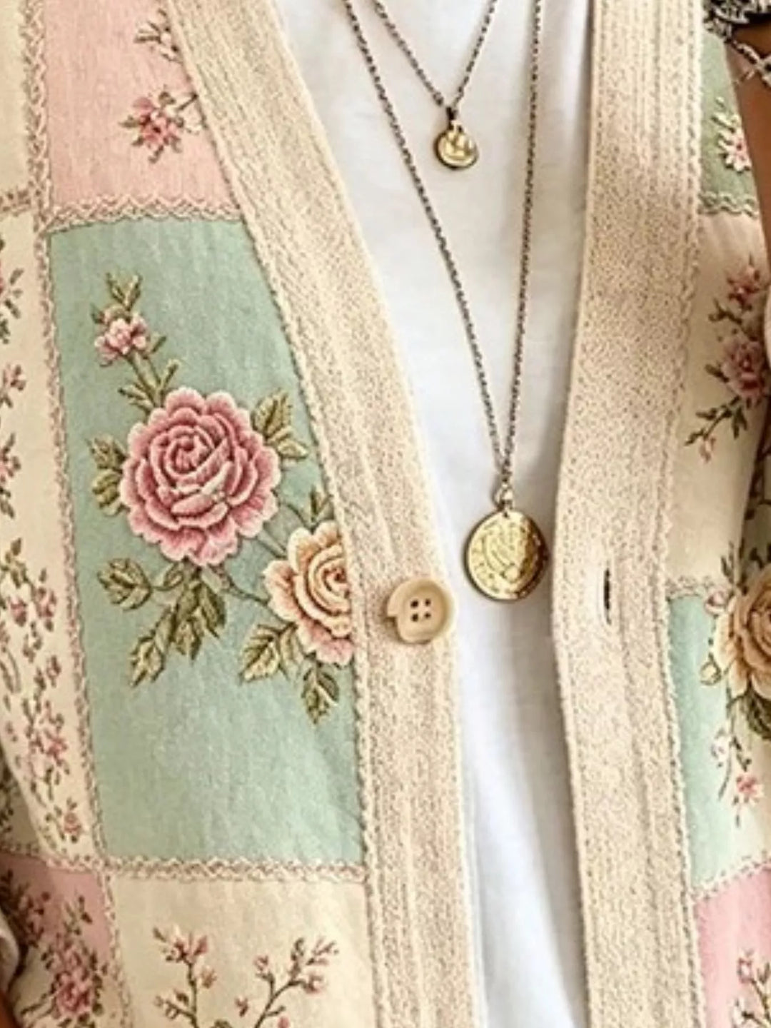Close-up of sage floral cardigan embroidered rose patch and wooden button