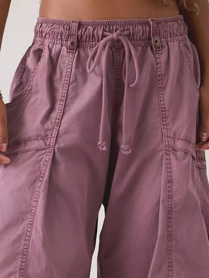 Close-up of mauve cargo pants waistband, drawstring and cargo pocket