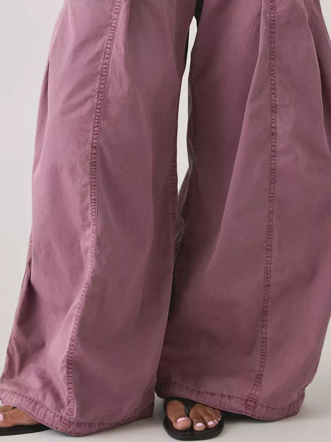 Close-up of mauve parachute cargo pants wide legs and hem