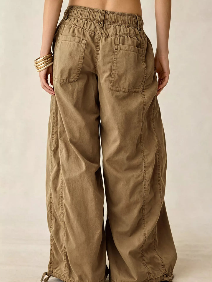 Back view of the tan wide leg cargo pants with drawstring hem