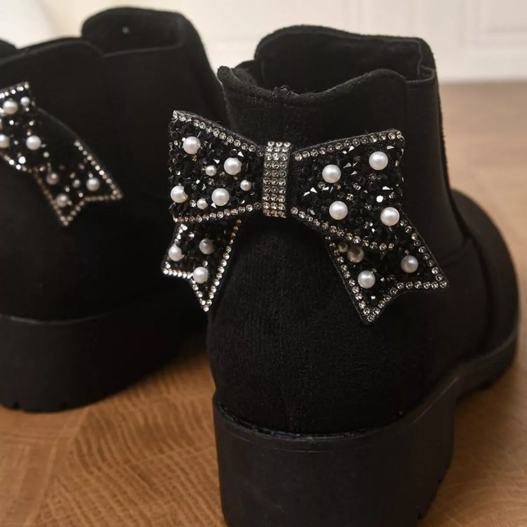 Close-up of the pearl and rhinestone bow on the black Chelsea boot