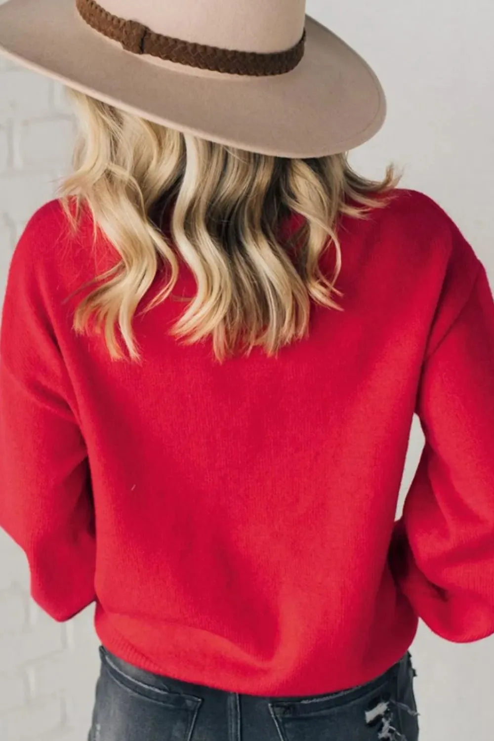 Back view of the red crew neck Christmas sweater with a wide brim hat