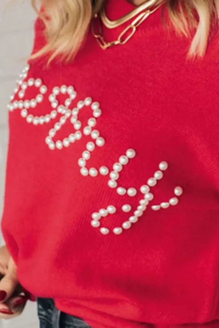 Close-up of the pearl beaded Merry lettering on the red crew neck sweater