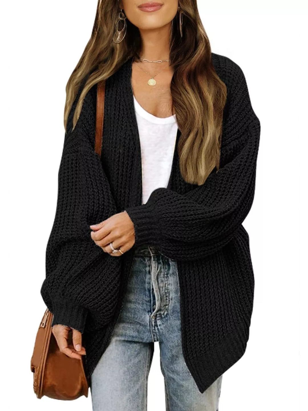 Black chunky knit cardigan worn open over a white tank with a brown bag