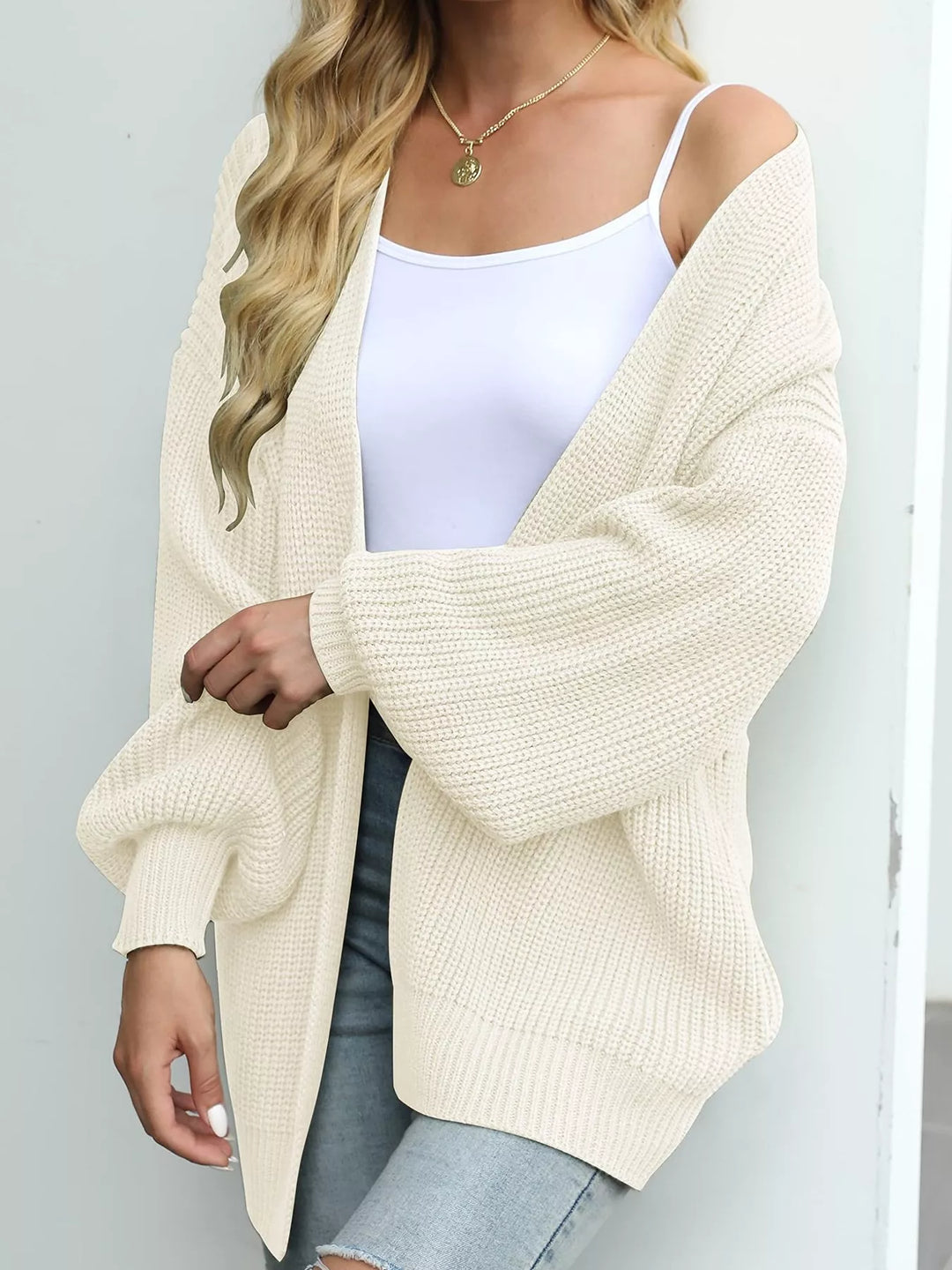 Cream oversized cardigan in a side view with a loose batwing sleeve