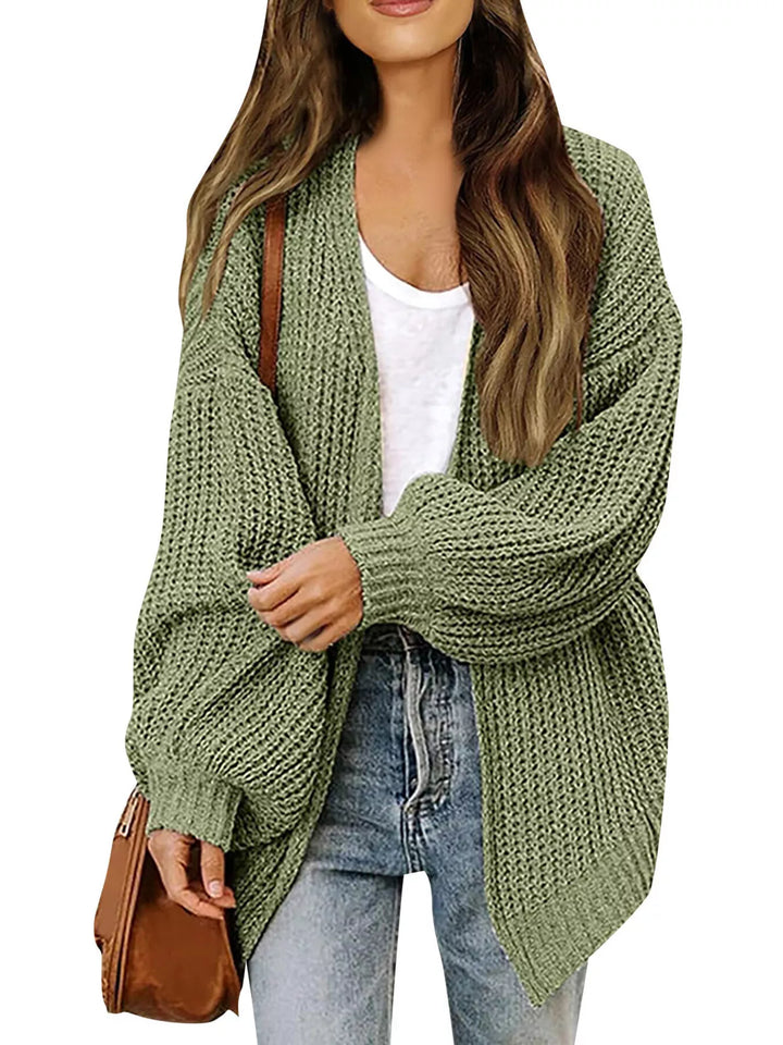 Olive chunky knit cardigan worn open with a white tank and jeans