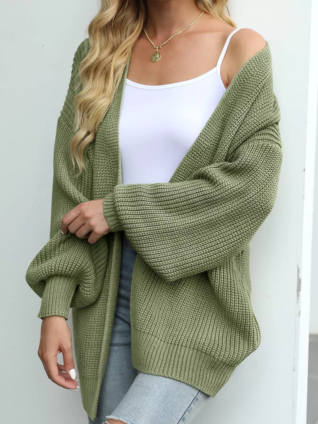 Sage green oversized open front cardigan with lantern sleeves, angled view