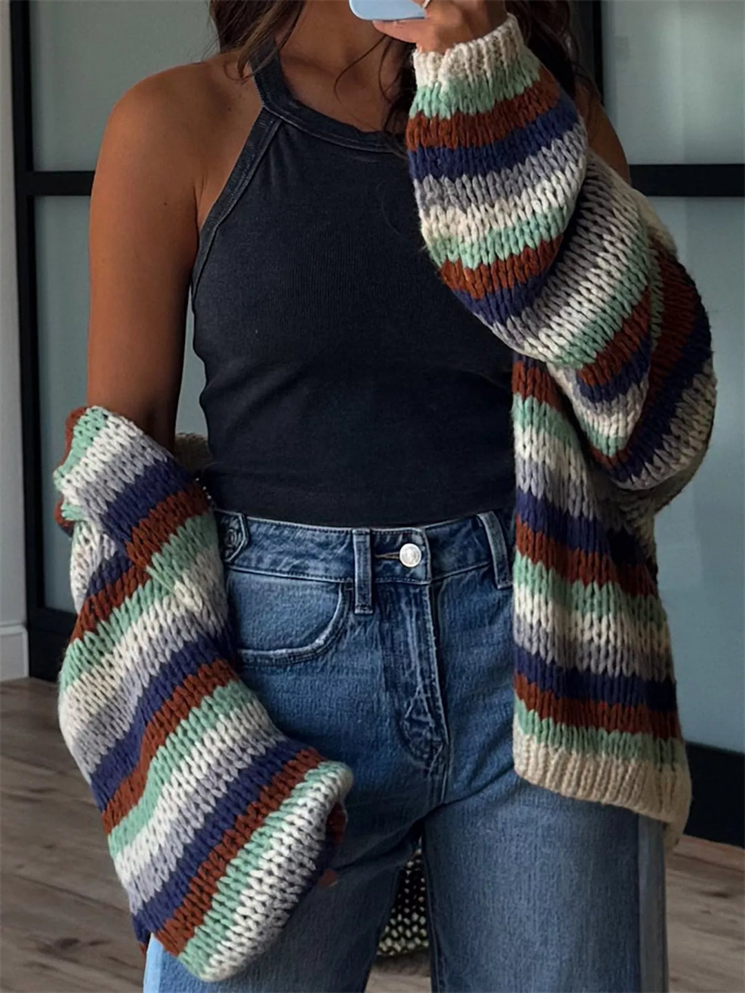 Close-up of the earth stripe knit cardigan sleeve in green, navy and cream