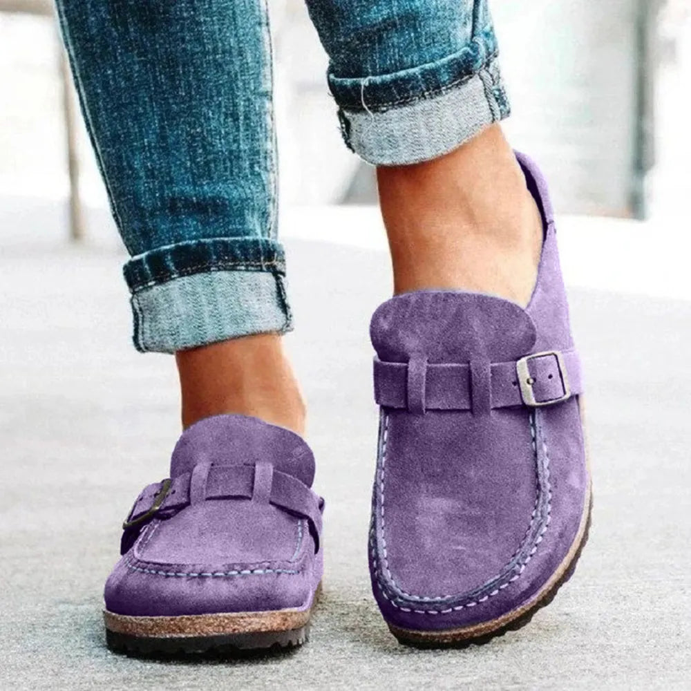 Lilac slip on clogs with buckle strap worn with rolled denim jeans