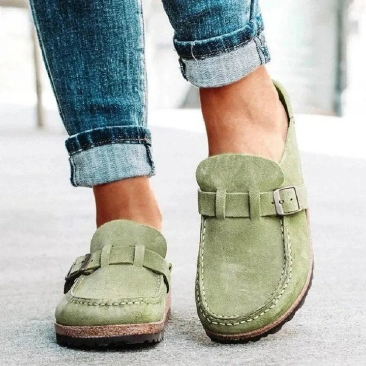 Sage backless wedge clogs with buckle strap, worn with cuffed jeans