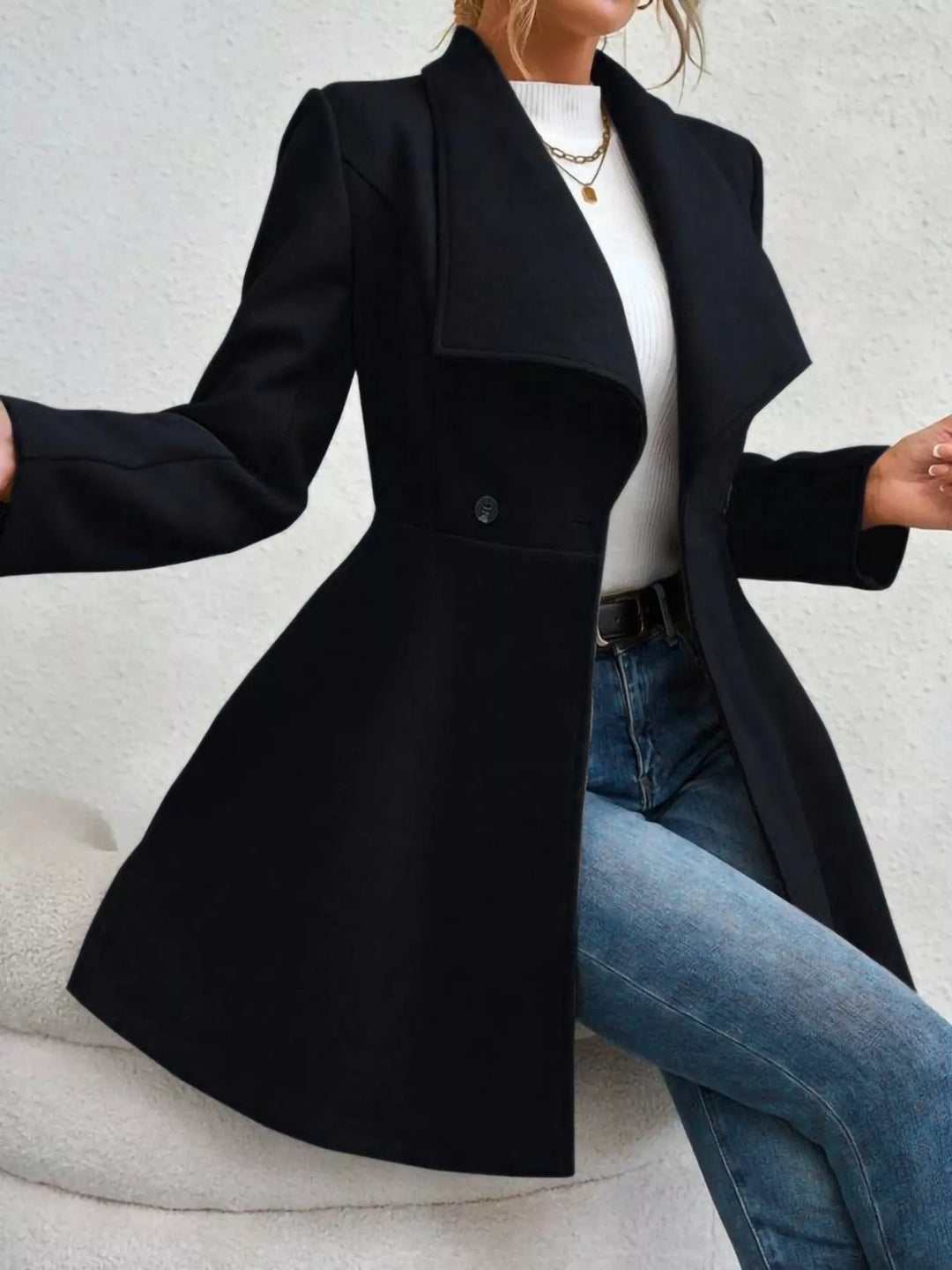 Black double breasted coat in a seated pose with arms out