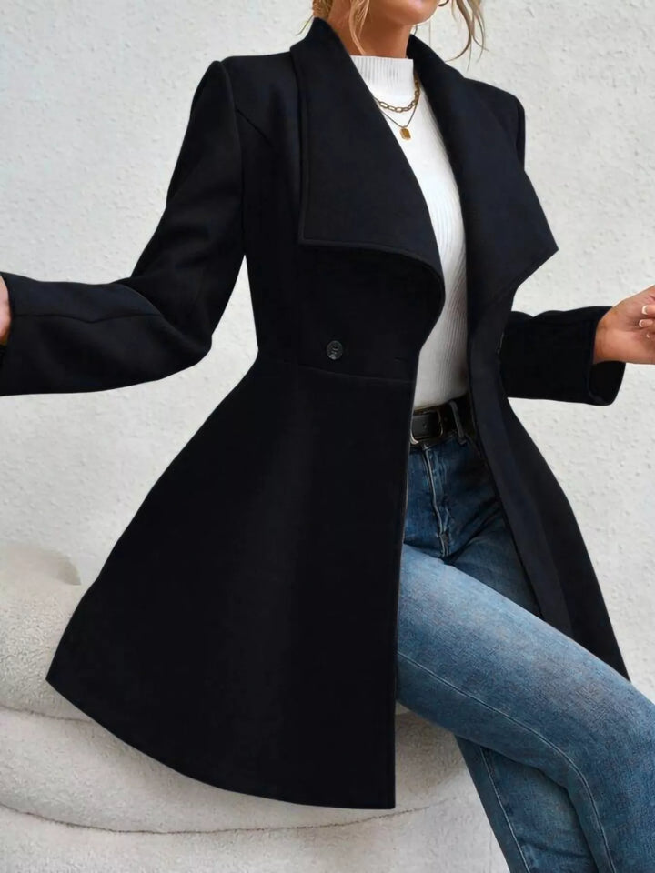 Black double breasted coat in a seated pose with arms out