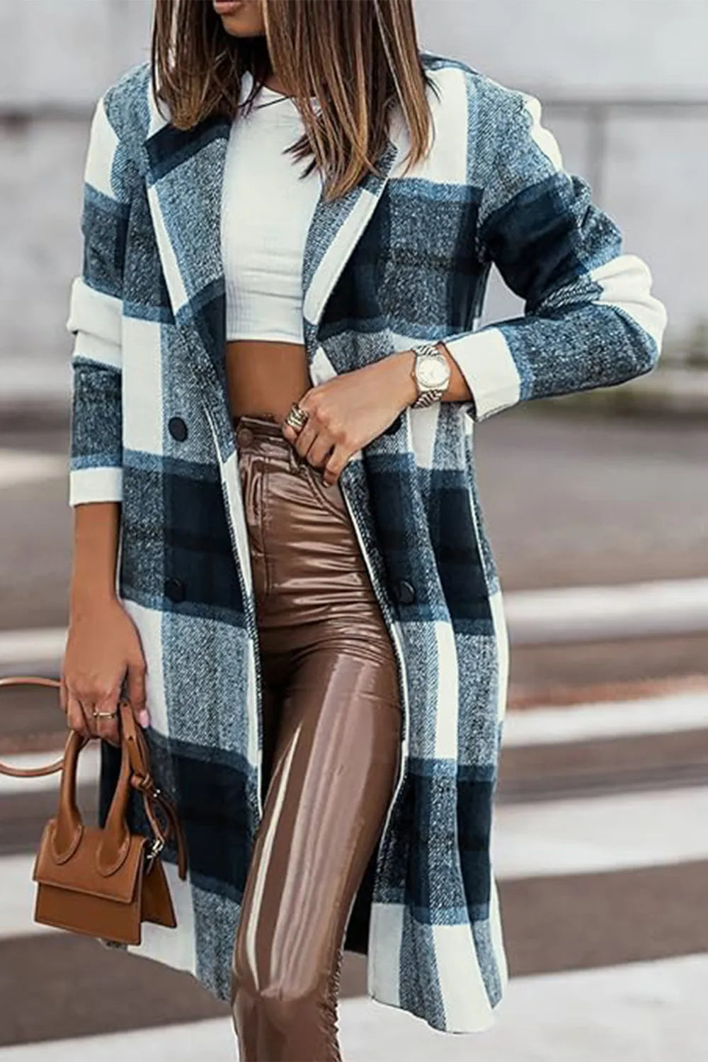 Close-up of navy plaid coat lapel with brown leather pants and a small bag