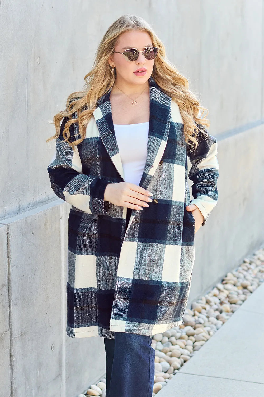 Navy plaid mid length coat with hand in pocket and flare jeans