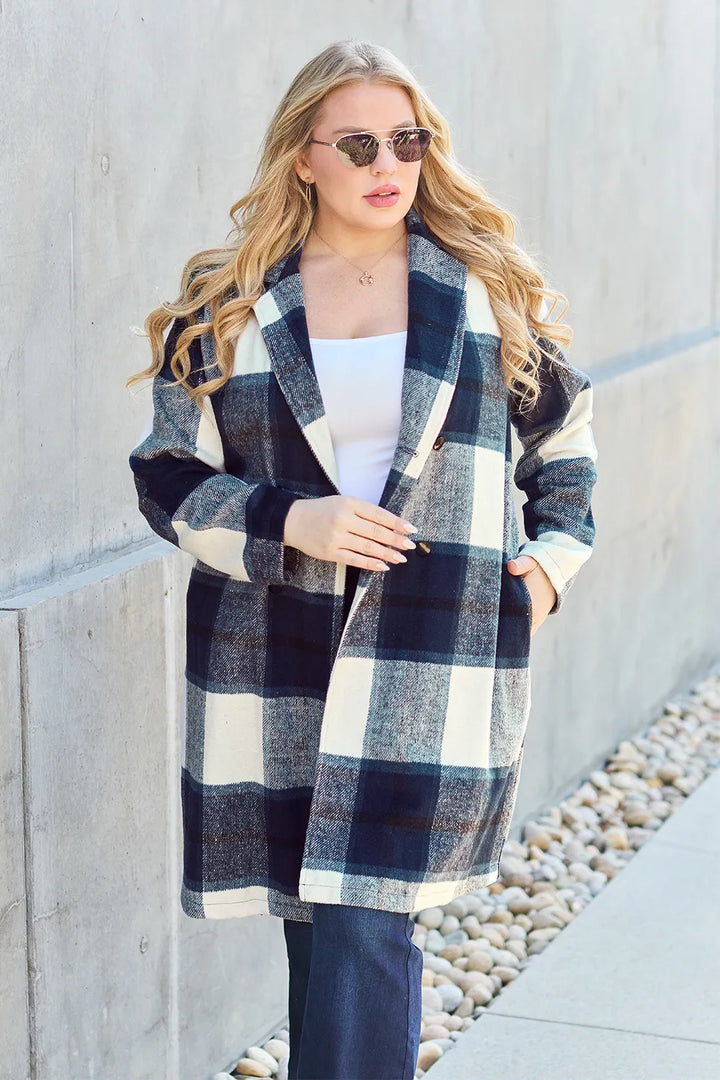 Navy plaid mid length coat with hand in pocket and flare jeans