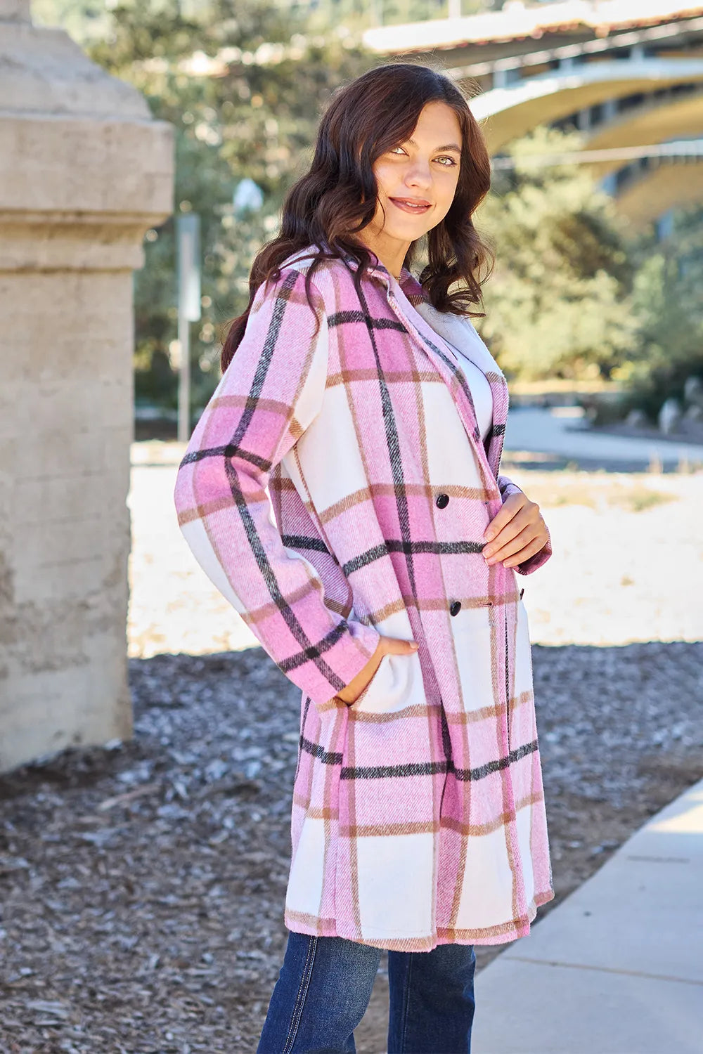 Pink plaid coat worn open with hand in pocket, angled view