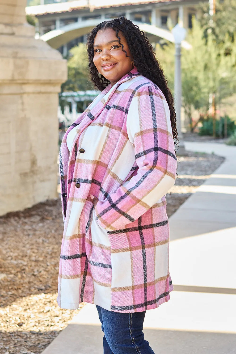 Pink plaid coat front view with buttons closed over a white top