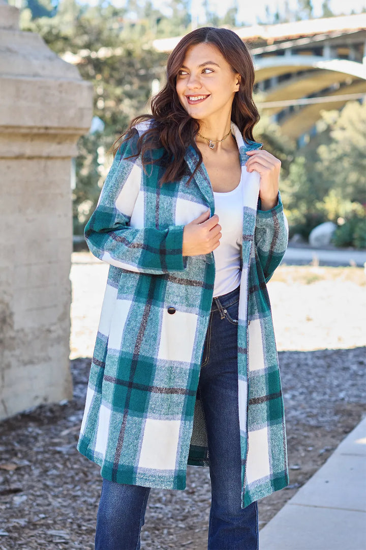 Teal plaid coat with notch lapel collar worn with jeans outdoors