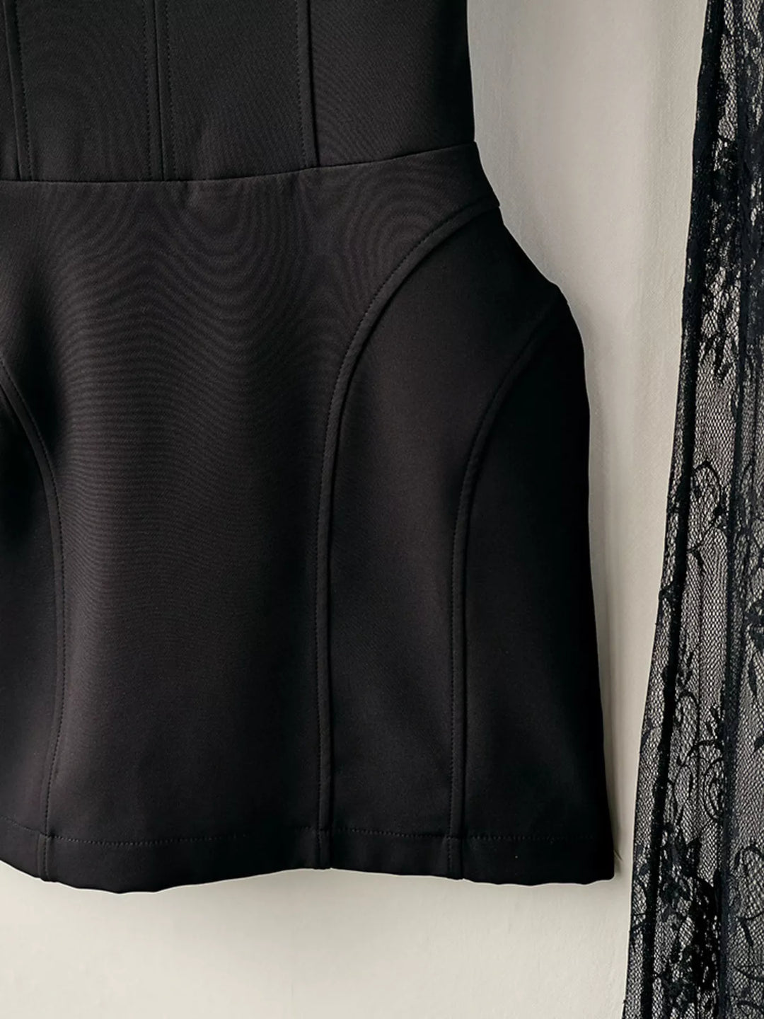 Side detail of the black mini skirt seams with lace overlay edge