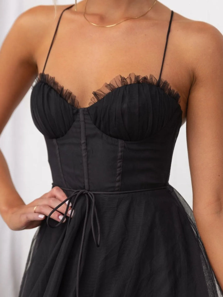 Black midi dress worn on a model, showing the corset bodice