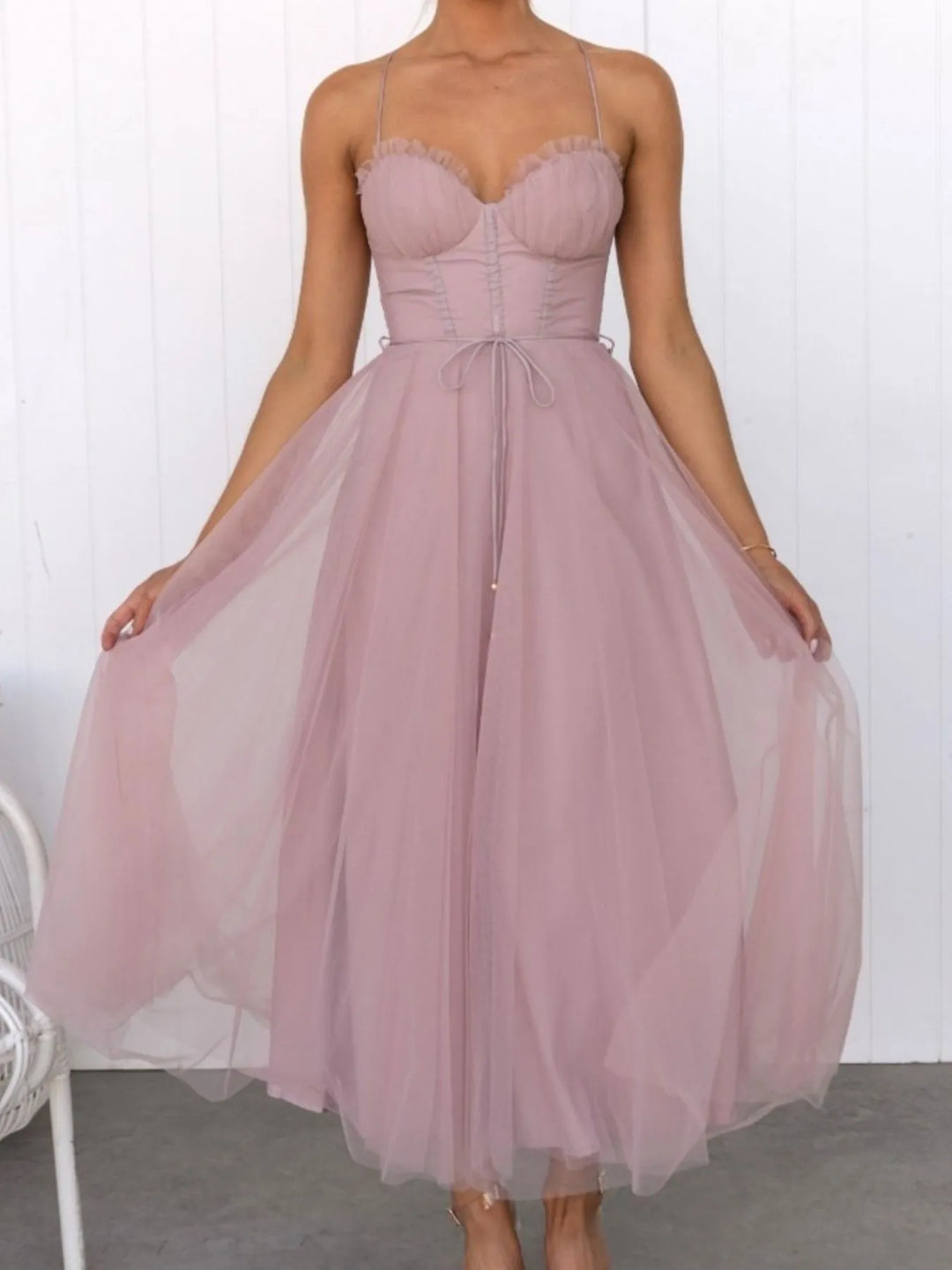 Pink midi dress worn on a model, showing the corset bodice