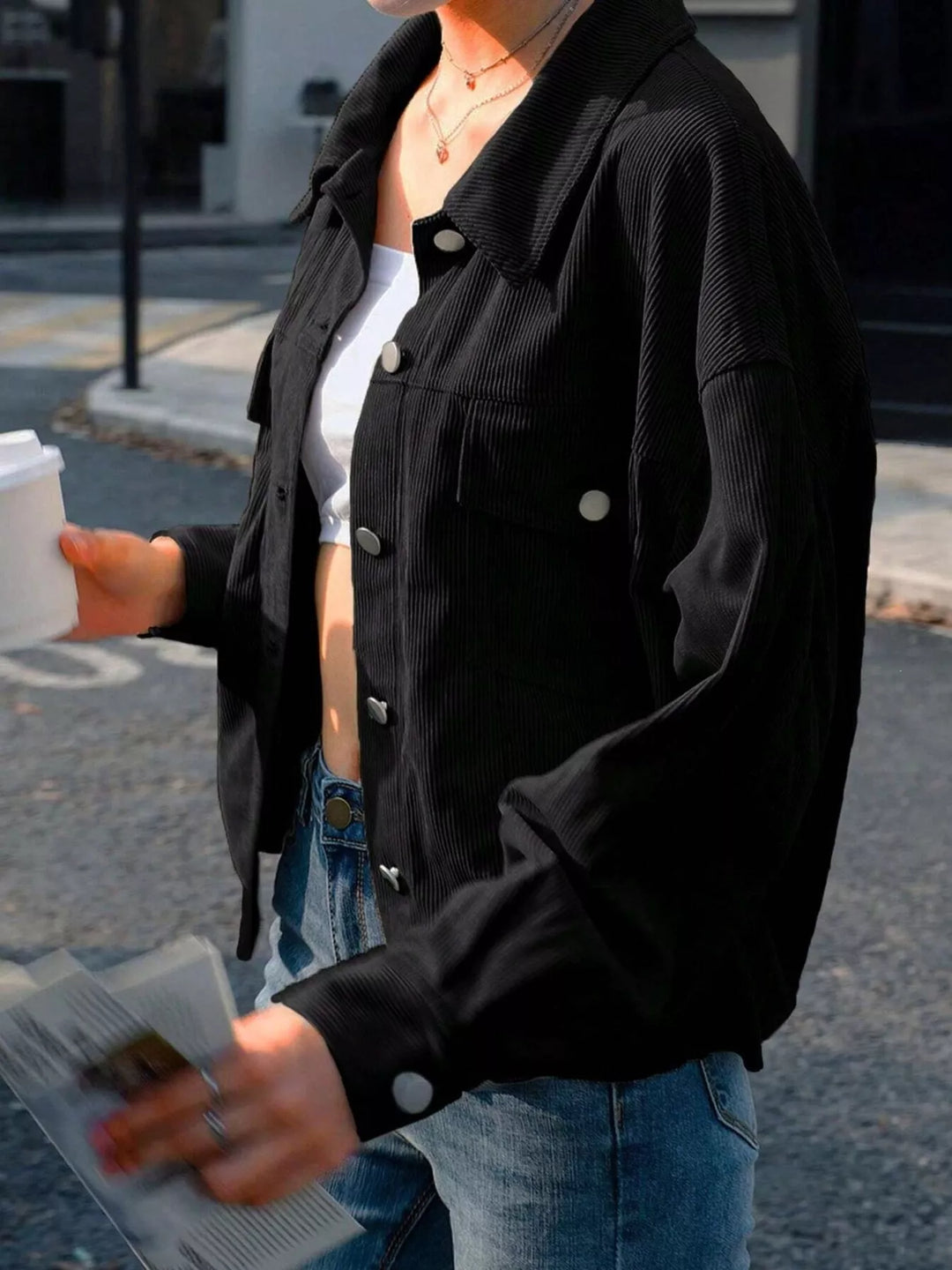Black button front cropped jacket in a street style side pose