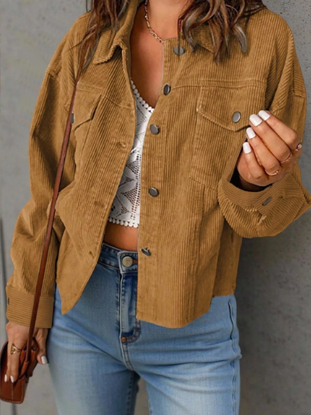 Camel cropped jacket with button front and pockets, worn with jeans