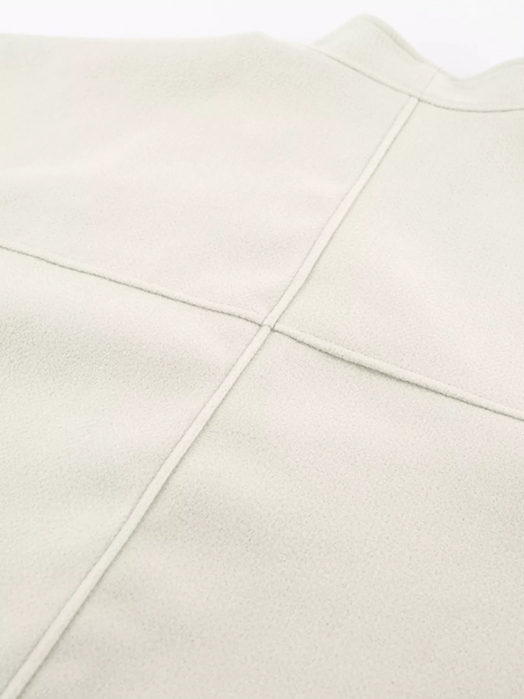Close-up of the ivory jacket back seam and shoulder