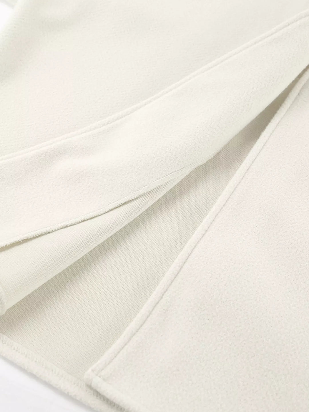 Detail of the ivory jacket side slit hem