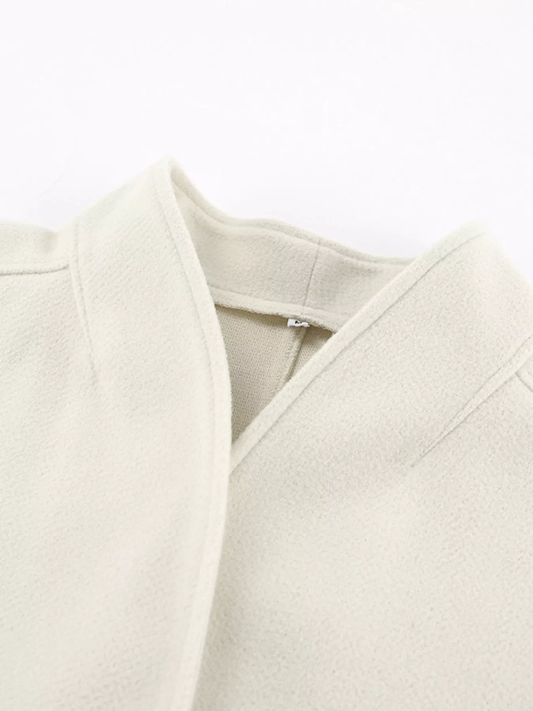 Detail of the ivory jacket open front neckline