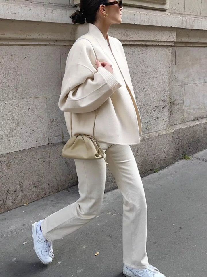 Ivory cropped jacket styled with white pants and sneakers
