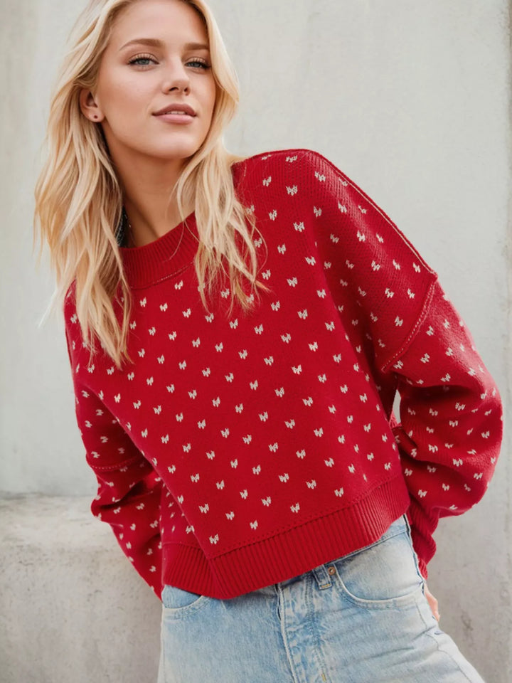 Red cropped sweater with white heart pattern worn with light wash jeans