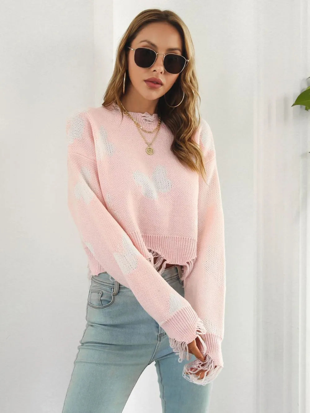 Blush pink distressed hem sweater, turned three quarter view