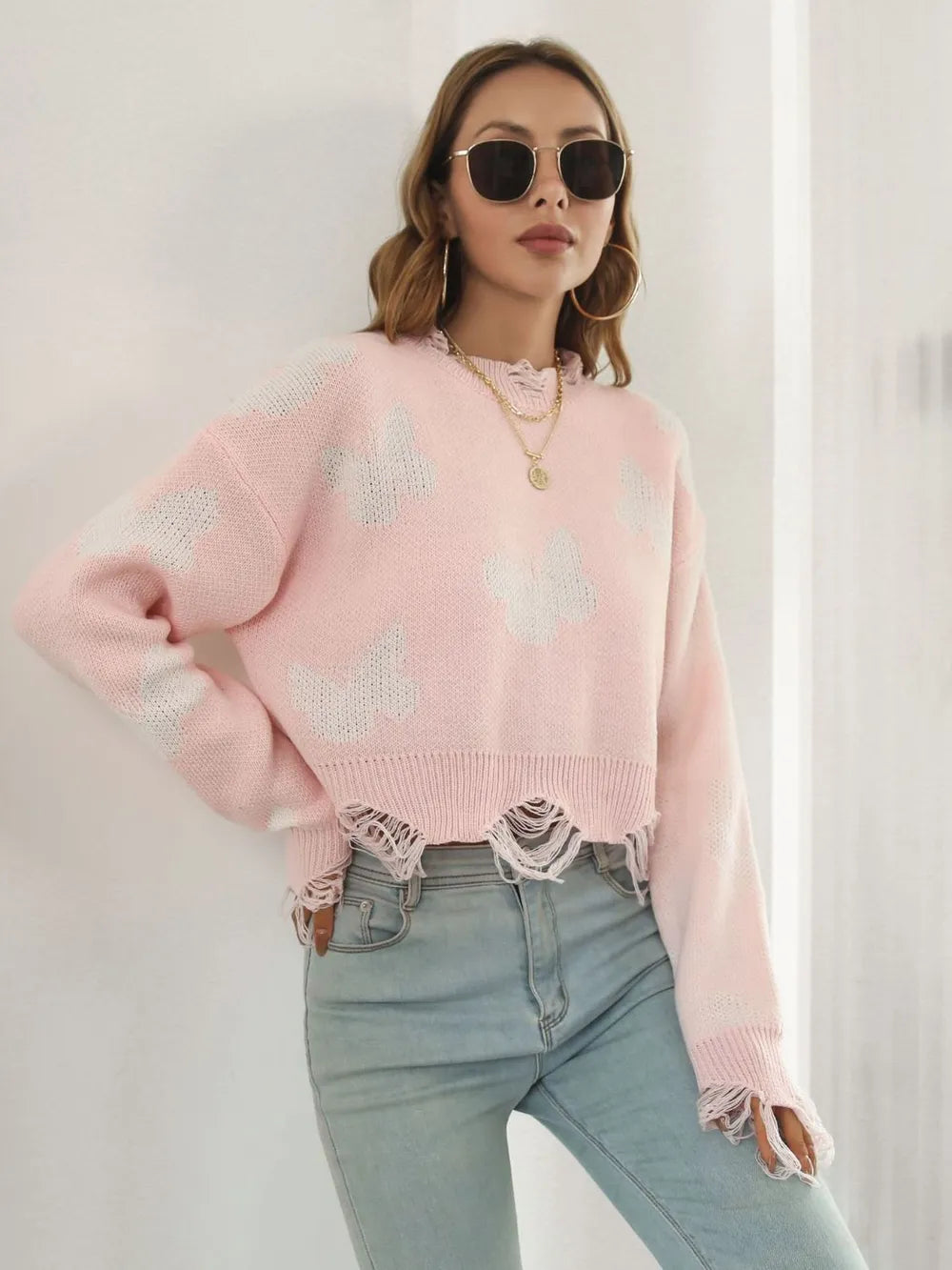 Blush pink crew neck cropped sweater in a relaxed side pose