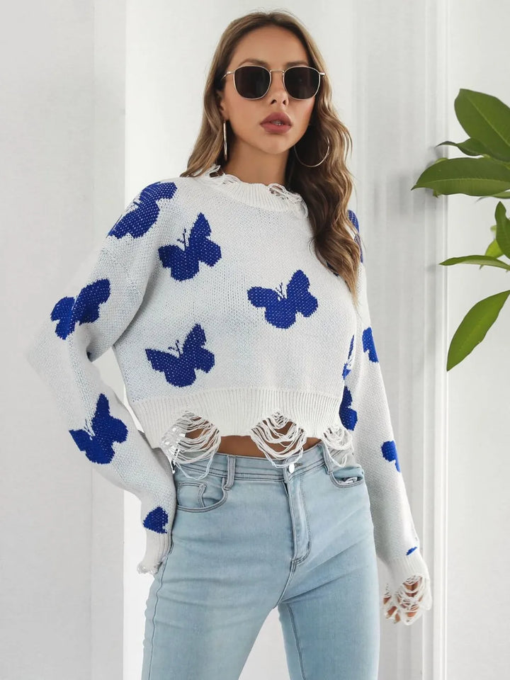 White crew neck cropped sweater with butterflies, hands on hips