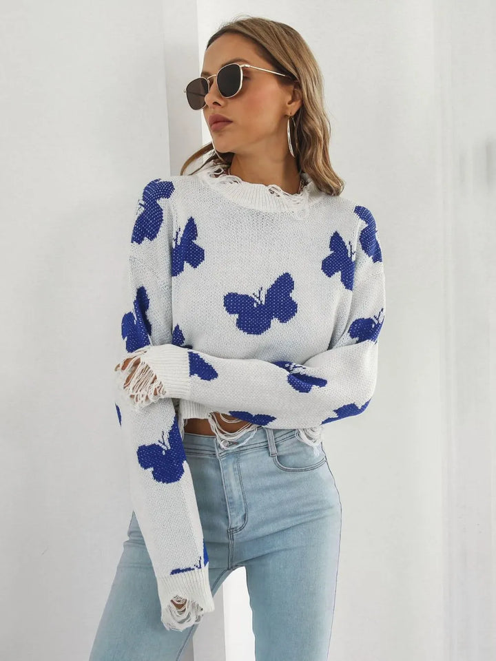 Side angle of the white cropped sweater showing the distressed sleeve