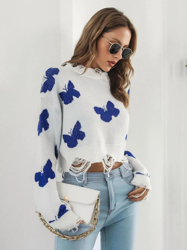 White butterfly sweater styled with a pearl chain handbag