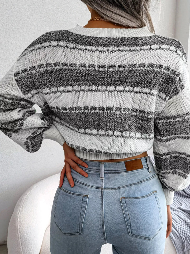 Back view of the dark gray striped cropped sweater with hand on waist