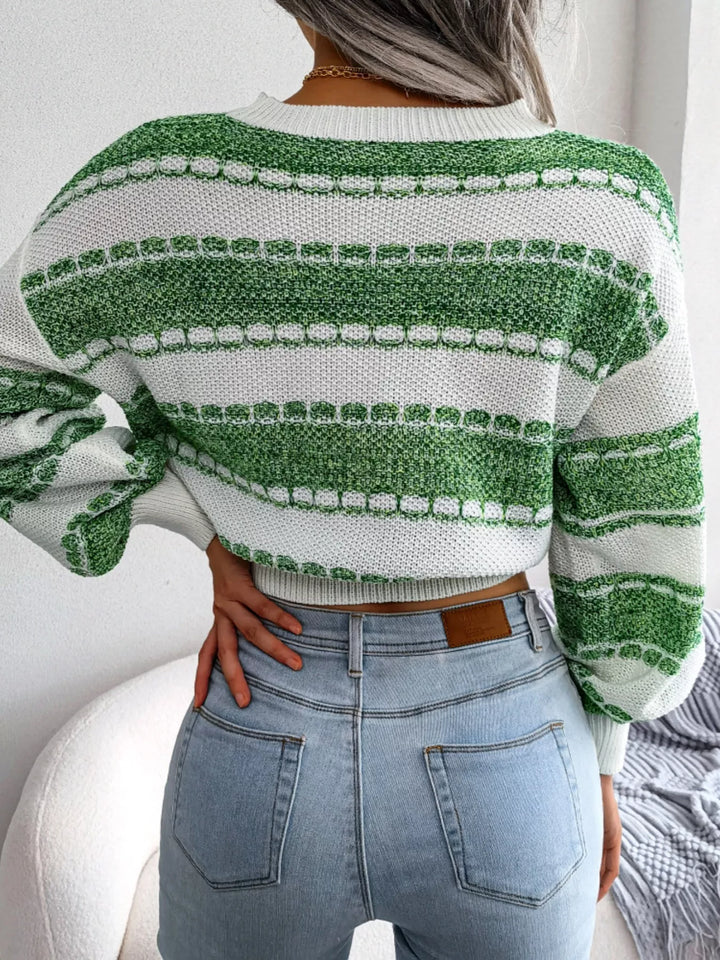 Back view of the green striped cropped sweater with hand on hip