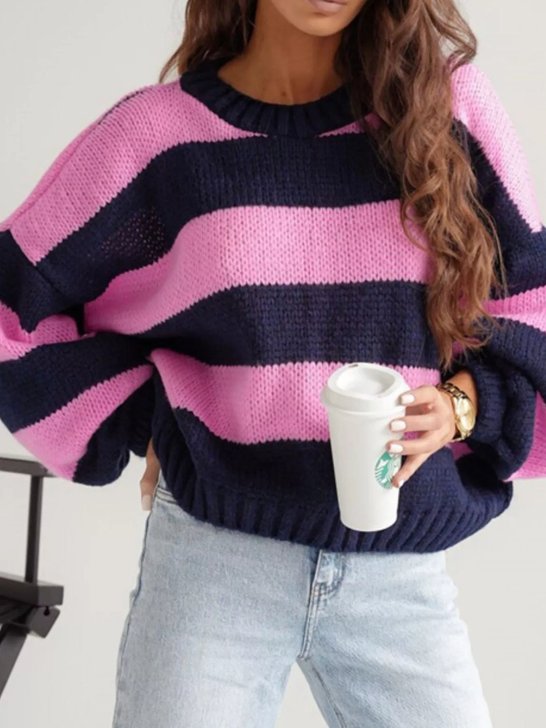 Pink and navy wide stripe cropped sweater with balloon sleeves, holding a cup