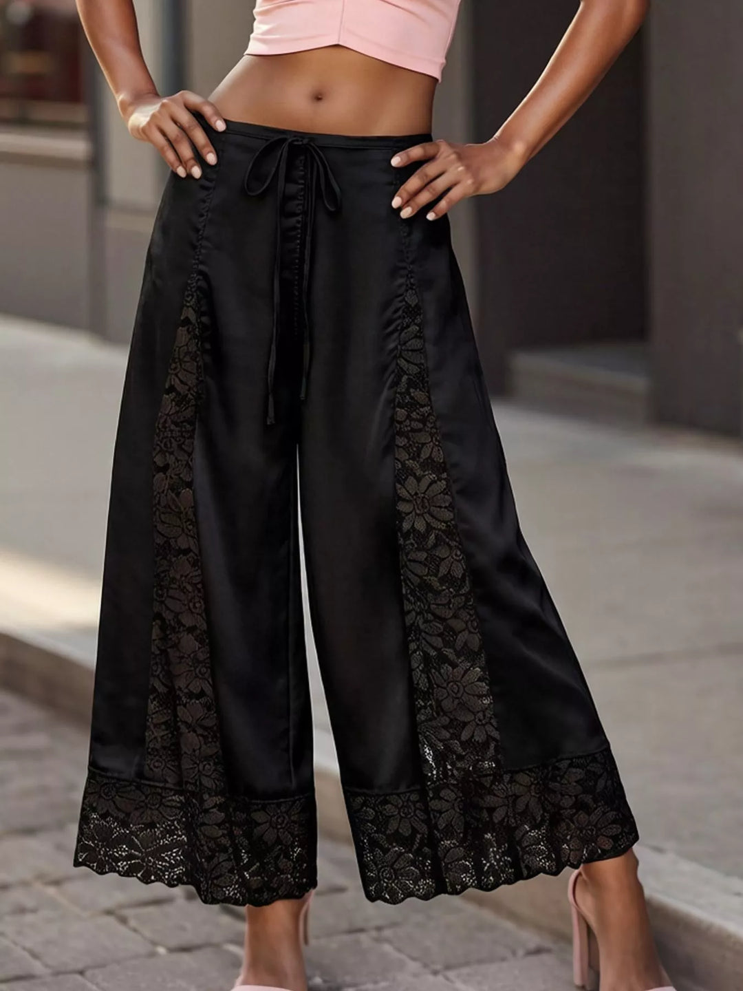 Close-up of the black wide leg pants lace panels and drawstring waist