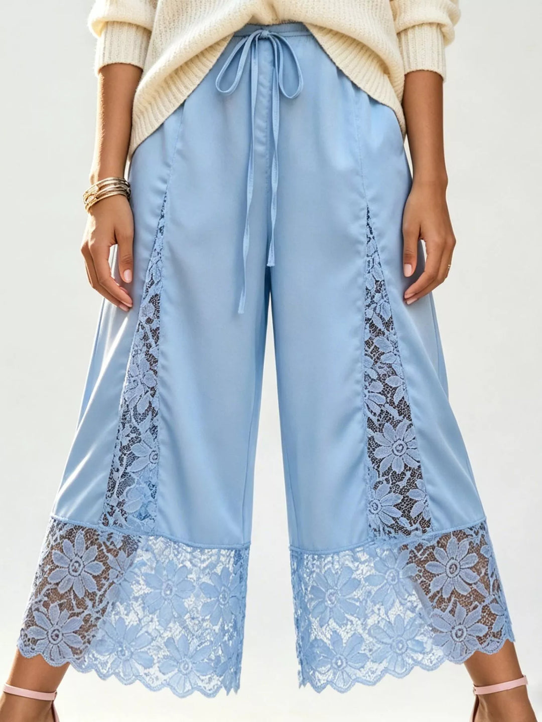 Light blue satin look cropped pants with lace inserts, full-length view with sweater