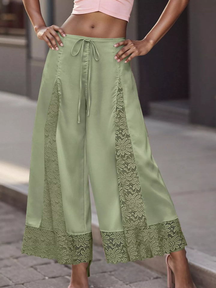 Sage green cropped wide leg pants with drawstring waist and lace panels, front view