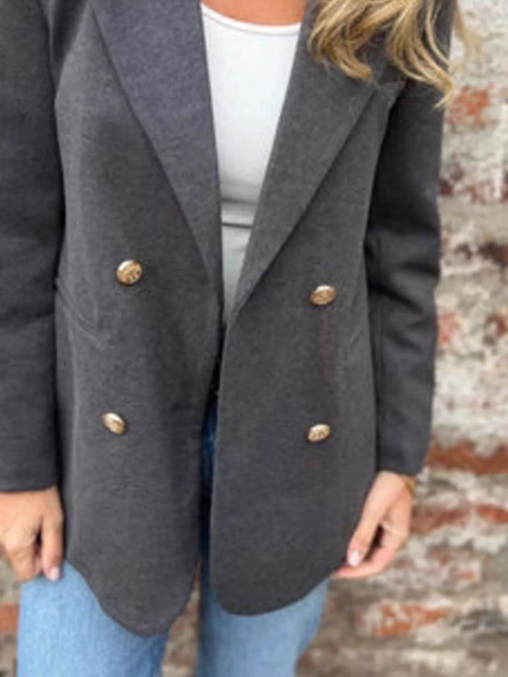 Close-up of the charcoal blazer lapel and gold button front