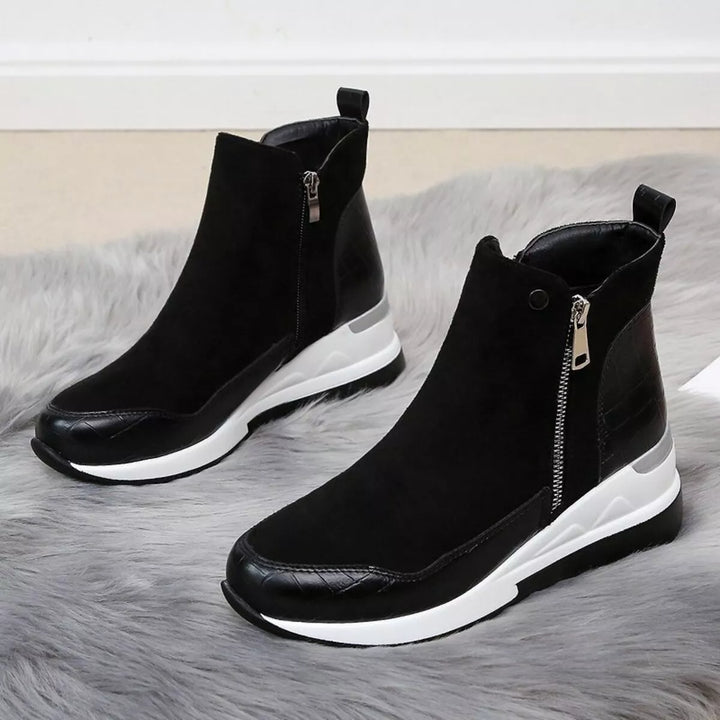 Women's fall boots in black, chunky wedge platform with side zip, pair on a fluffy rug