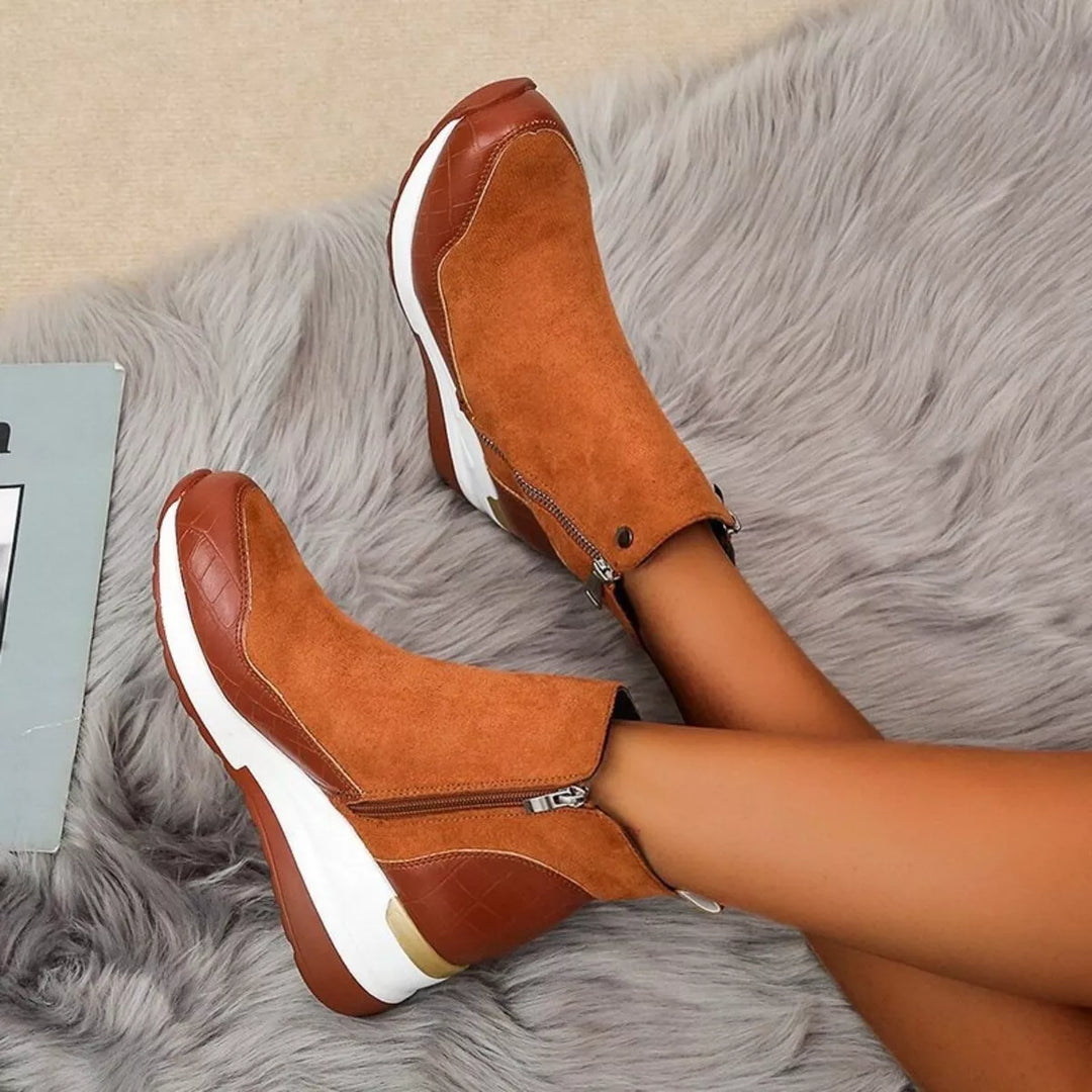 Cognac platform wedge boots worn with legs crossed, side zipper visible