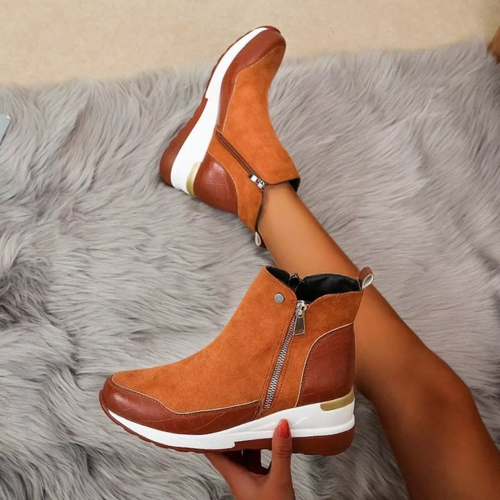Cognac wedge platform boots with side zip, one held up to show the sole