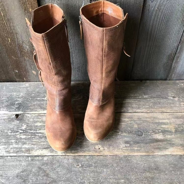 Pair of brown mid calf boots on a wooden bench, front view