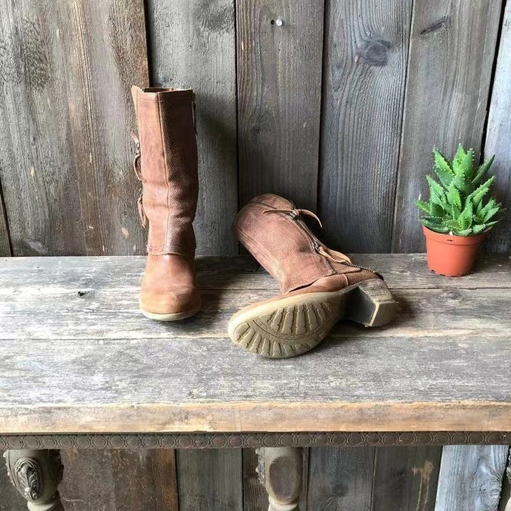 Brown mid calf boot tipped over to show the sole and stacked heel